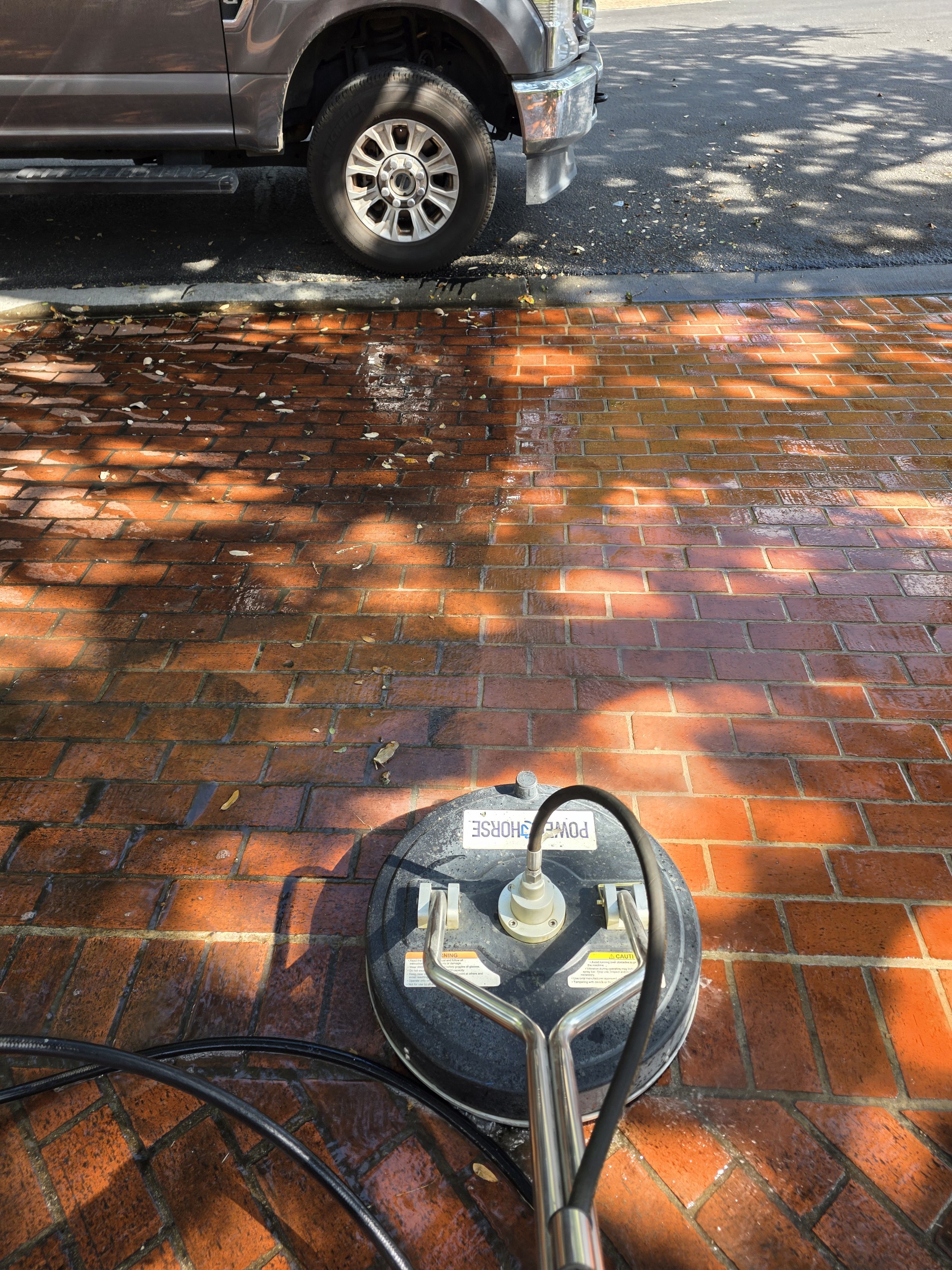 A surface cleaner on a brick paver driveway