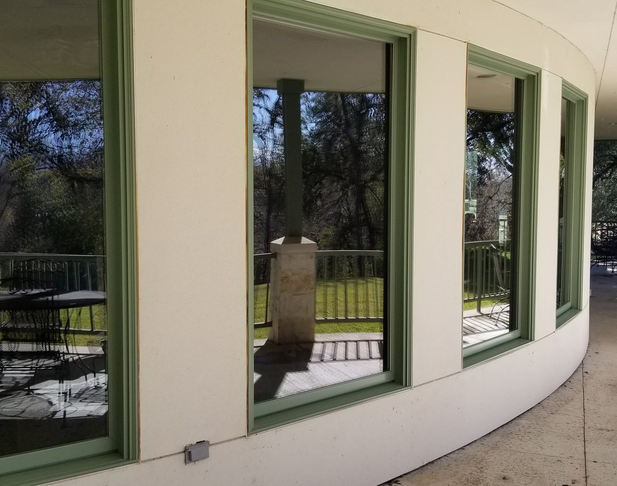 Curved wall of green-framed windows